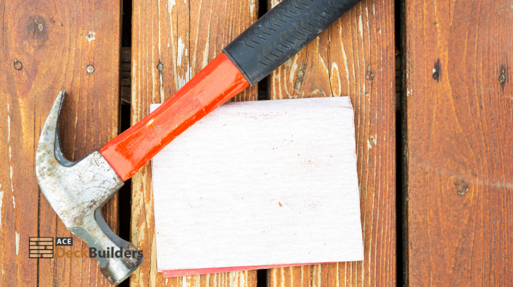hammer and sand paper on wooden surface