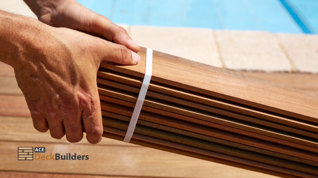 person holding pile of deck boards